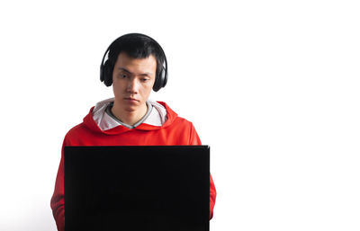 Portrait of teenage boy standing against white background