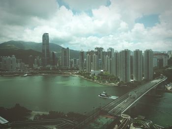 View of cityscape against cloudy sky