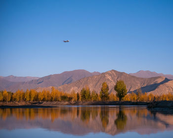 Scenic view of lake and mountains against clear sky