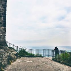 Man photographing sea against sky
