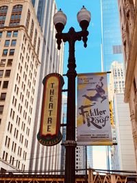 Low angle view of road sign on street against buildings