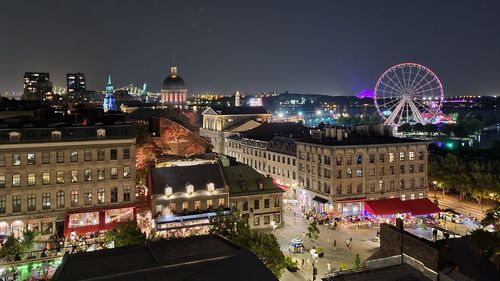 High angle view of illuminated ferris wheel in city at night