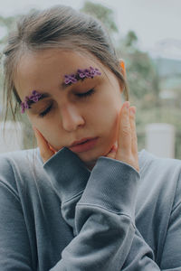 Close-up portrait of a young woman and lilac flowers