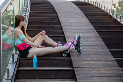 Side view of woman sitting on staircase