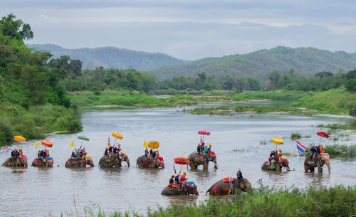 People riding elephant in lake