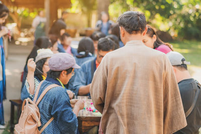 Rear view of people sitting on street in city