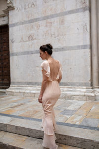 Rear view of woman standing on steps of building