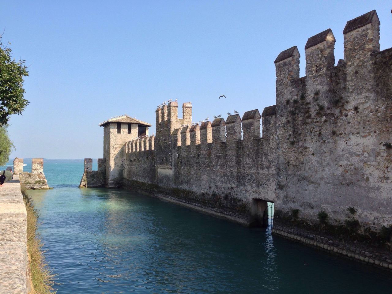 architecture, built structure, water, building exterior, sea, clear sky, blue, waterfront, copy space, horizon over water, rippled, day, building, residential structure, house, sunlight, outdoors, residential building, nature, sky