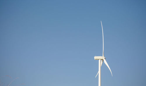 Wind turbine on field against sky