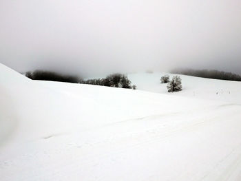 Snow covered field against sky