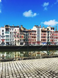 Canal by buildings against sky