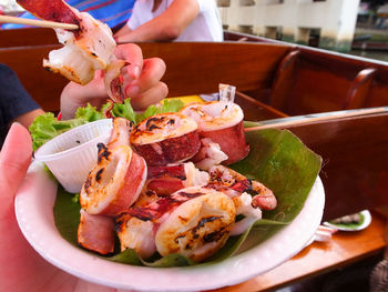 Cropped image of people eating fresh seafood