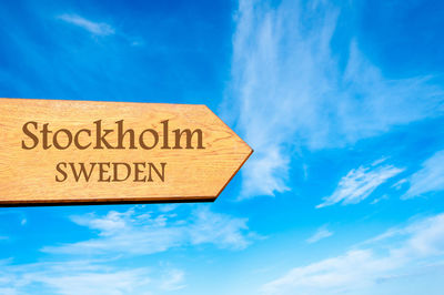 Low angle view of information sign against blue sky