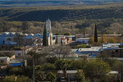 High angle view of trees and buildings in city, village church