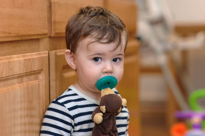 Portrait of a boy toddler with a pacifier at home
