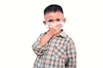 Portrait of boy standing against white background