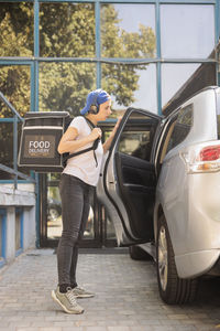 Rear view of man standing in car