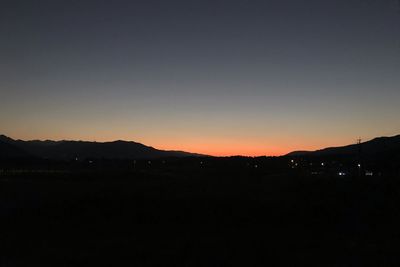 Silhouette of city against clear sky during sunset