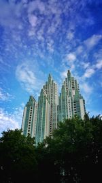 Low angle view of modern building against cloudy sky