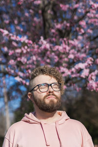 Portrait of young man standing against plants