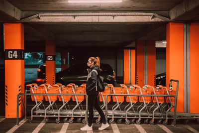 Full length portrait of woman standing in shopping cart