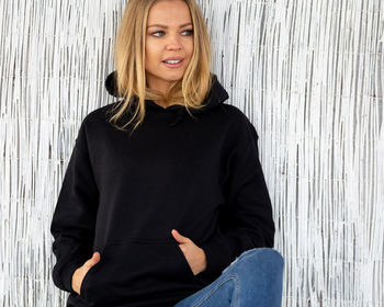 Portrait of smiling woman against wall