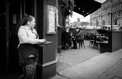 Woman standing at cafe in city