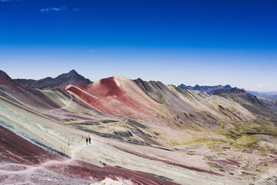 Scenic view of landscape and mountains against blue sky