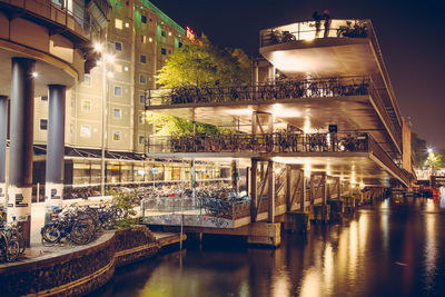 Illuminated bridge over river at night