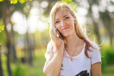 Young woman looking away while standing outdoors