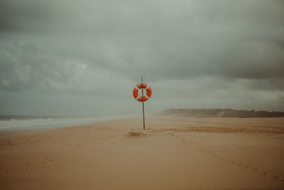 Sign on beach against sky