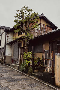 Houses by street against sky in city