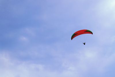 Low angle view of person paragliding against sky