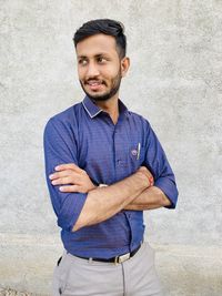 Portrait of smiling man standing against wall