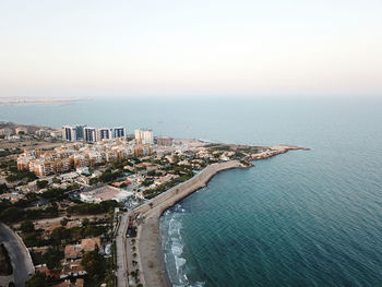 High angle view of sea by buildings against sky