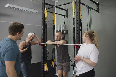 Smiling people talking together in gym