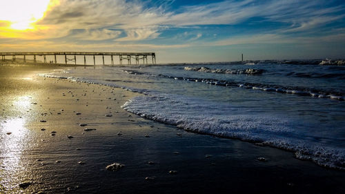 Scenic view of beach against sky during sunset