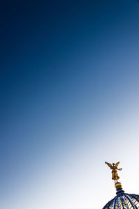 Low angle view of statue against clear blue sky