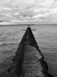 Jetty in sea against sky