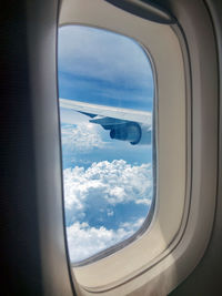 View of cloudy sky seen through airplane window