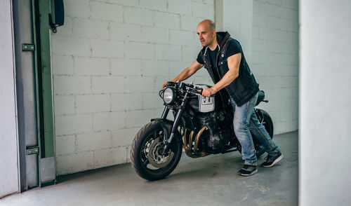 Mechanic with motorcycle at garage