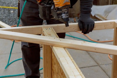 Low section of man standing on wood