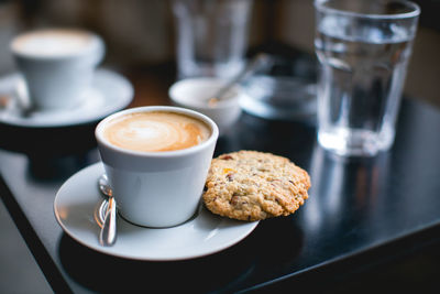 Close-up of coffee with cookie on table