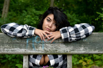 Portrait of sensuous woman leaning on wooden railing