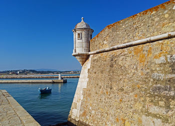 View of building by sea against clear sky