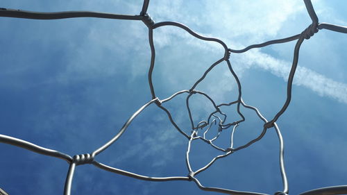 Low angle view of chainlink fence against sky