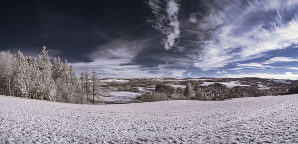 Scenic view of snow covered field against sky