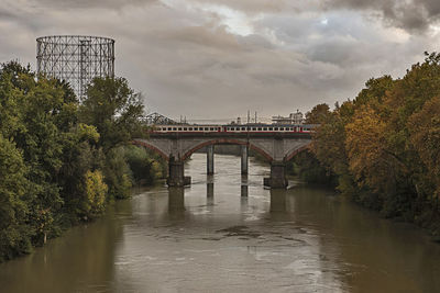 Arch bridge over river against sky