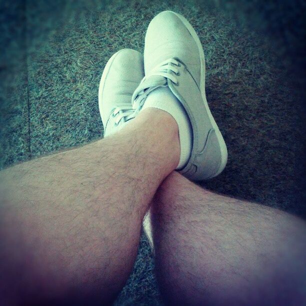 low section, person, shoe, personal perspective, human foot, jeans, lifestyles, footwear, relaxation, indoors, part of, high angle view, leisure activity, legs crossed at ankle, close-up, standing