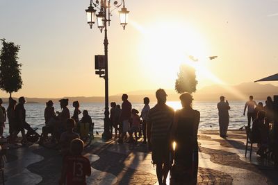 People at beach during sunset